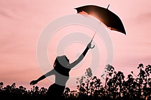 Unplugged free silhouette woman with umbrella fly to future