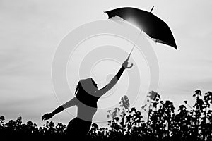 Unplugged free silhouette woman umbrella up to black white sky