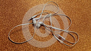 Unplugged white headphone golden background