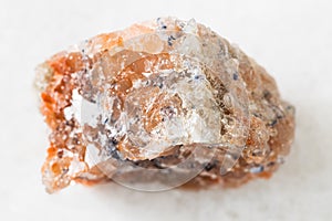 unpolished red Rock Salt (Halite) on white marble