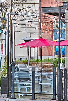 Unpopulated street cafe under red umbrellas on a winter season