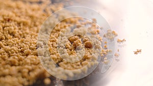 Unprocessed unrefined brown raw sugar on shiny glass. Natural sweetener.