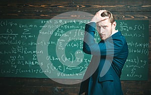 Unproven theorem. Man formal wear classic suit looks smart, chalkboard background. Genius suffers unresolved mathematics