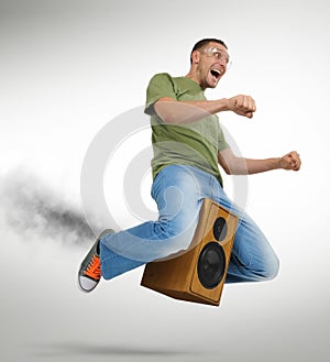 Unreal flying man sitting on a speaker