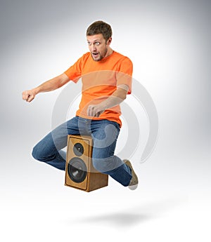 Unreal flying man sitting on a speaker