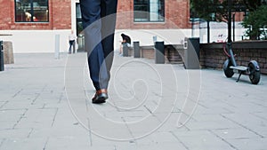 Unrecognisable businessman feet walking in the business district