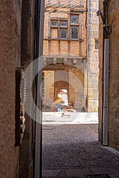 Unrecognisable child cyclist in the medieval district of Figeac, France