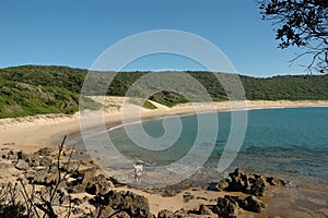 Unrecognisable man and two kids walking on a remote pristine white beach