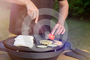 Unrecognisable man using electric grill. Garden grill party, summer barbecue