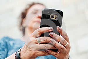 unrecognisable mature woman chatting on smart phone