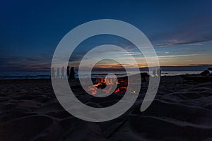 Unrecognisable people celebrating summer solstice with bonfires on beach