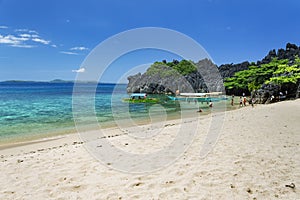 Unrecognisable people playing by the Banca boats on Lahus Island beach, Caramoan, Camarines Sur Province, Luzon in the Philippines