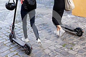 Unrecognisable women riding around on electric scooters