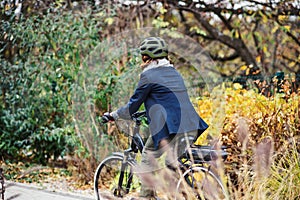 Unrecognizable active senior woman with electrobike cycling outdoors in park.