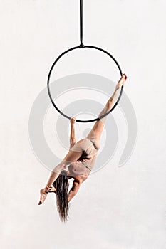 Unrecognizable aerialist exercising on aerial hoop