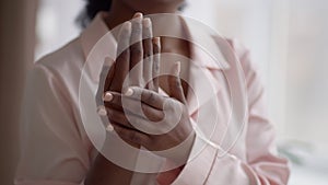 Unrecognizable African American Young Lady Applying Moisturizer On Hands Indoor