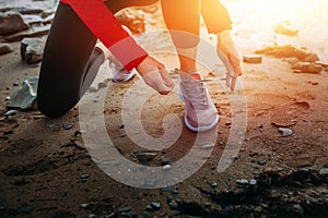 Unrecognizable Athletic Young Woman Tying Shoelaces Near The Sea