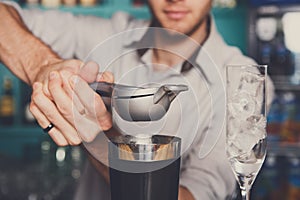 Bartender making cocktail with lime, close-up