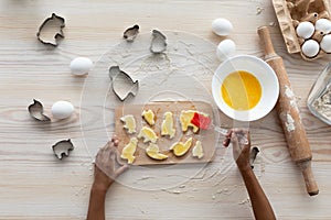 Unrecognizable black girl making cookies, top view