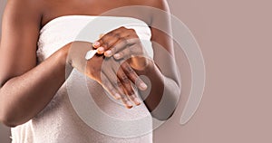 Unrecognizable Black Lady Wrapped In Towel Applying Hand Cream, Using Moisturising Lotion