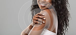 Unrecognizable black woman enjoying her smooth skin over grey background photo