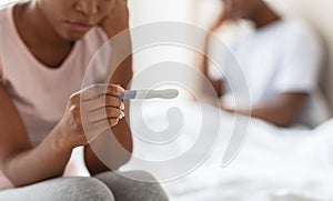 Unrecognizable black woman holding pregnancy test, unintended pregnancy concept photo