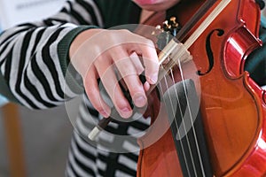 Unrecognizable boy is learning to play violin.