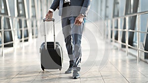 Unrecognizable Business Guy Walking With Suitcase In Airport Terminal