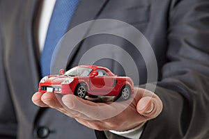 Unrecognizable businessman showing a toy car