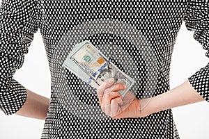 Unrecognizable businesswoman hiding money behind back