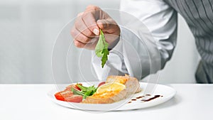 Unrecognizable Chef Man Decorating Salmon Steak With Herbs In Kitchen