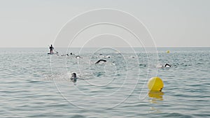unrecognizable children and teenagers participate in open water sea swimming competitions