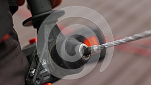 Unrecognizable construction worker on a construction site, holding a work tool, drill or power tools in the hands