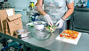 Unrecognizable cook preparing takeaway orders