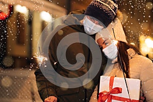 Unrecognizable Couple Hands holding and waving sparklers. Party on occasion of New Year, Christmas Eve or Xmas