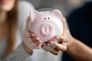 Unrecognizable Couple Holding Pink Piggybank In Hands, Saving Money For Future