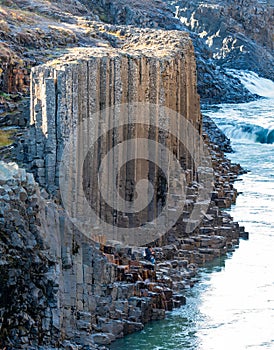 Unrecognizable couple inside basalt columns and river canyon