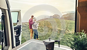 Unrecognizable couple traveling in camper van looking coastline landscape