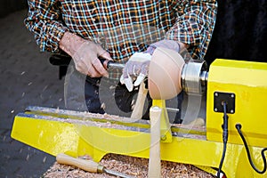 Unrecognizable craftsman turning wood with lathe