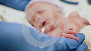 Unrecognizable doctor examining premature baby with stethoscope at neonatal intensive care unit in hospital. Newborn is