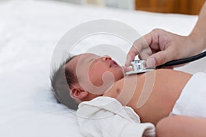 Unrecognizable Doctor heart check up and diagnosis baby newborn with stethoscope in clinic or hospital.Examining heartbeat of