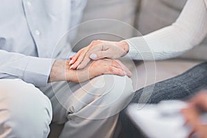 Unrecognizable elderly couple holding hands at session