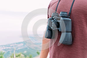 Unrecognizable explorer man with binoculars in nature.