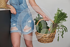 Unrecognizable farmer holding fresh vegetables basket picked in the garden.