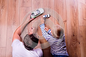 Unrecognizable father with his son playing with cars