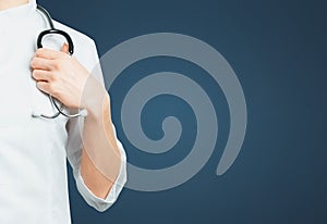 Unrecognizable Female Doctor In Medical Coat With Stethoscope on Blue Background. Medicine Insurance Healthcare Concept