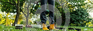 Unrecognizable female gardener standing in her ornamental backyard garden. Planting seedlings, starting cut flower garden.