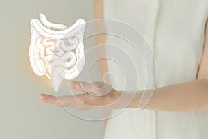 Woman in white clothes holding virtual intestine in hand. Handrawn human organ, detox and healthcare, healthcare hospital service photo
