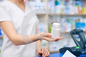Unrecognizable female pharmacist giving pills.