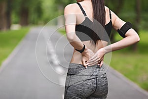 Unrecognizable Female Suffering From Back Pain After Running Outdoors, Having Sport Injury